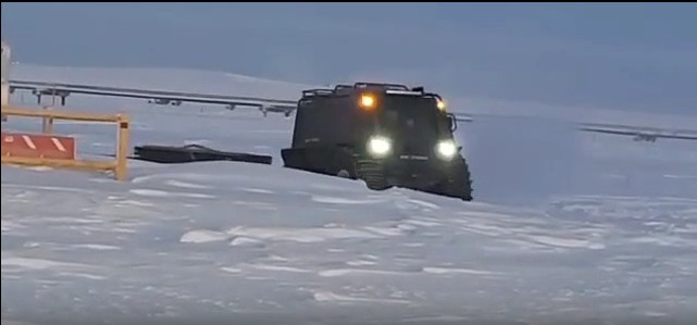 Fat Truck FT3 2.8 wagon all-terrain vehicle with headlights on driving through deep snow in winter arctic conditions