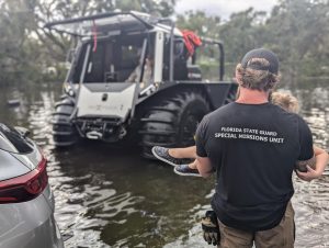 Fat Truck amphibious rescue vehicle evacuating civilian during hurricane flood with Florida State Guard Special Missions Unit