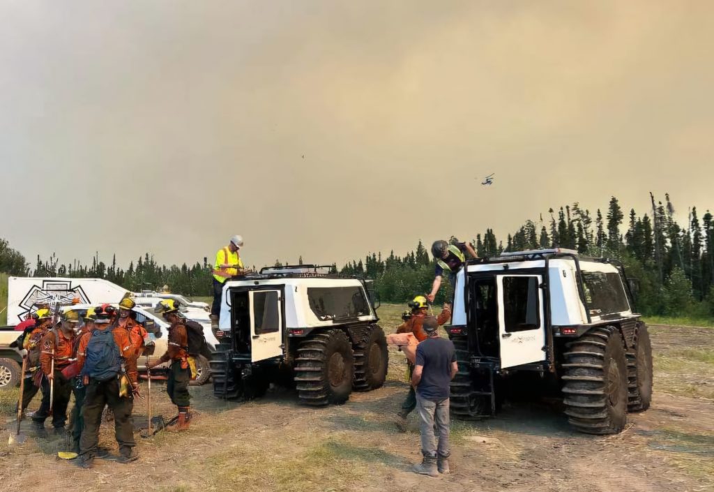 Two Fat Truck all-terrain vehicles transporting wildfire crew through forest during active fire operations