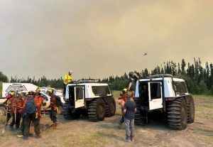 Two Fat Truck all-terrain vehicles transporting wildfire crew through forest during active fire operations