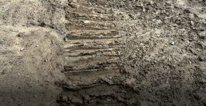 Close-up of Fat Truck oversized tire tread pattern pressed into soft mud, showing low ground pressure off-road capability
